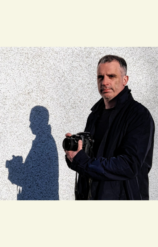 Author photograph of Duncan Simpson holding a camera