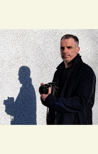 Author photograph of Duncan Simpson holding a camera